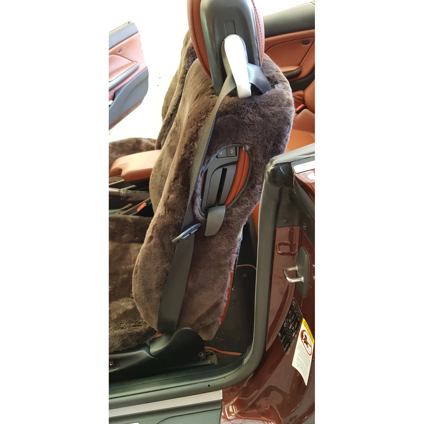 Detailansicht der mit Lammfell in Farbe Mocca bezogenen Rückenlehne mit integriertem Sicherheitsgurt im BMW E46 Cabrio