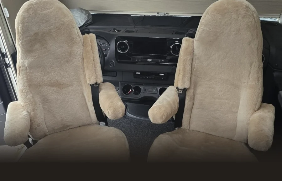 Autositzfelle aus Lammfell in Sand auf den Pilotensitzen eines Wohnmobils