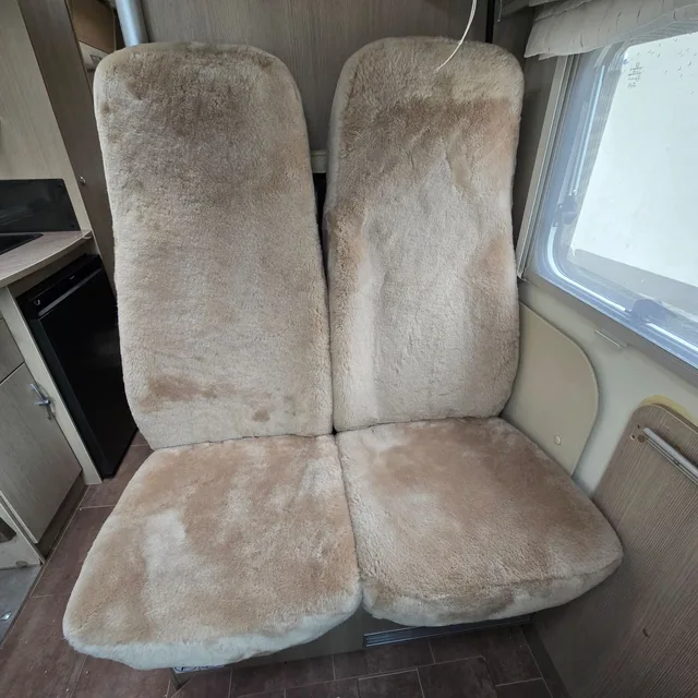 Hintere Einzelsitze eines Wohnmobils mit maßgefertigten Sitzbezügen aus Lammfell in Farbe Sand