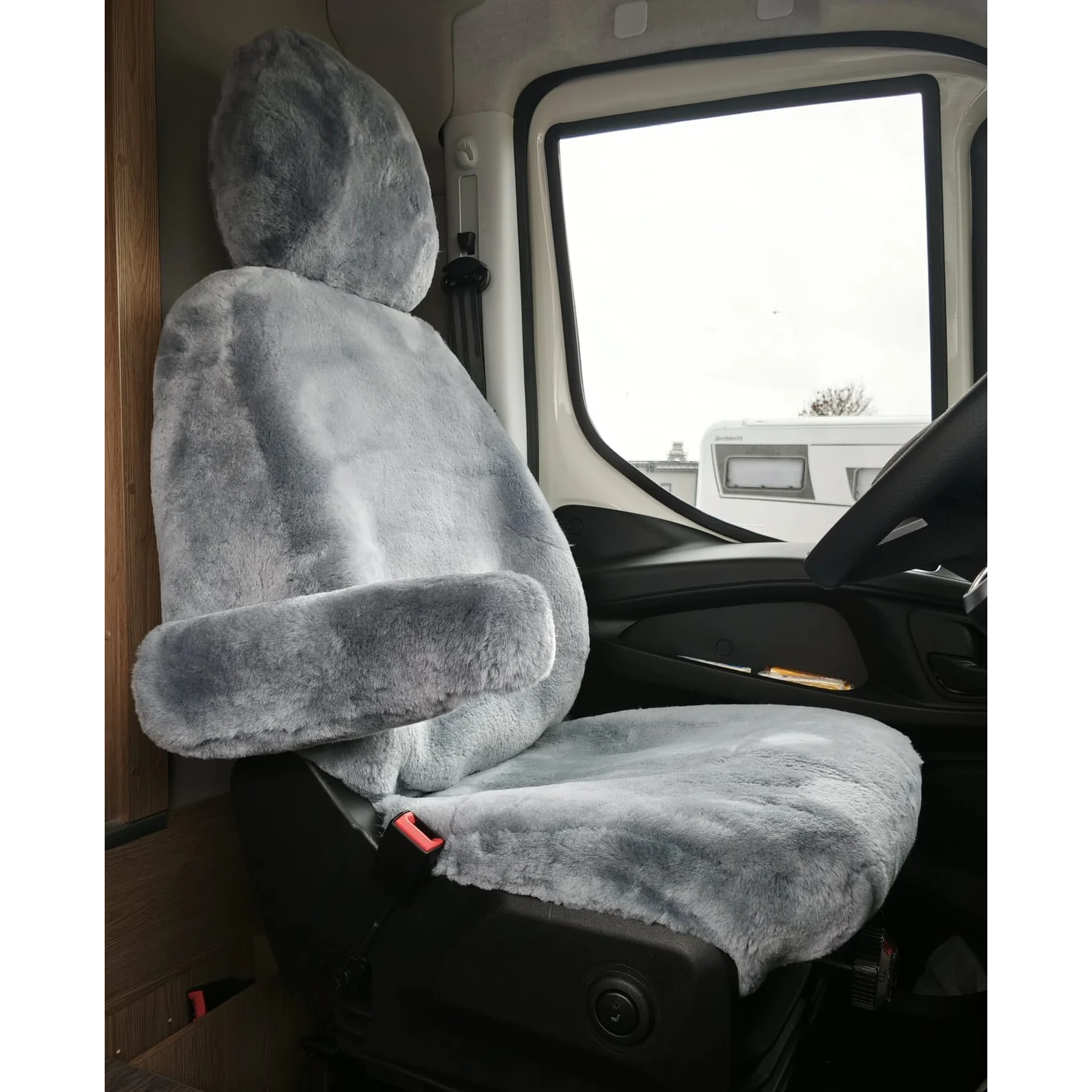 Maßgefertigter Autositzbezug aus Lammfell für Iveco Daily VII in Farbe Silber auf dem Fahrersitz mit separater Kopfstütze und Armlehne, Vorderansicht