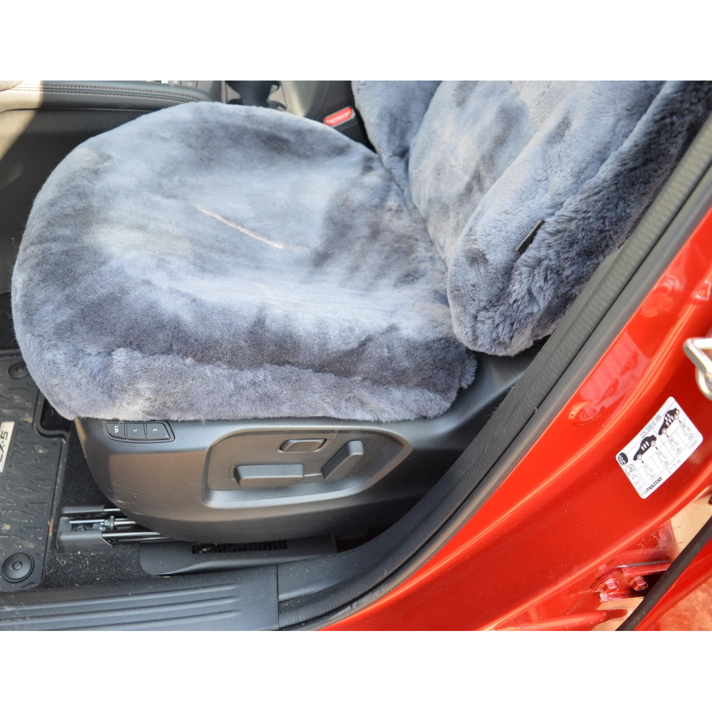 Detailansicht der mit Lammfell in Farbe Anthrazit maßgefertigt bezogenen Sitzfläche im Mazda CX-5 KF