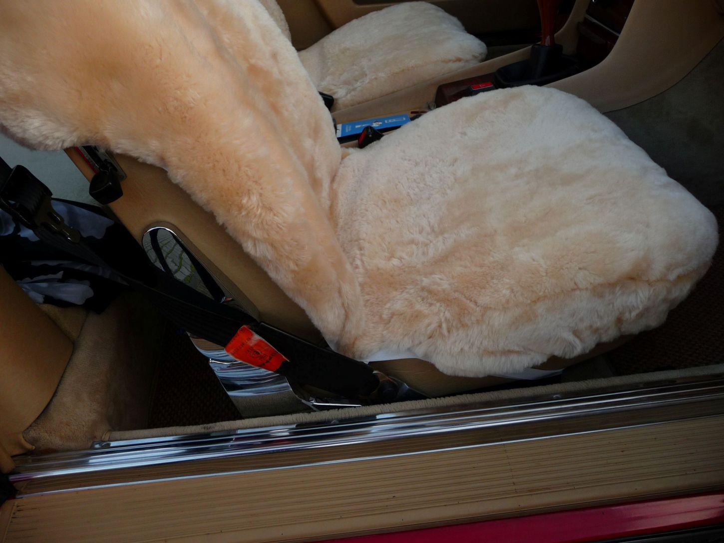 Detailansicht der mit Lammfell in Farbe Sekt bezogenen Sitzfläche im Mercedes R107 SL-Klasse