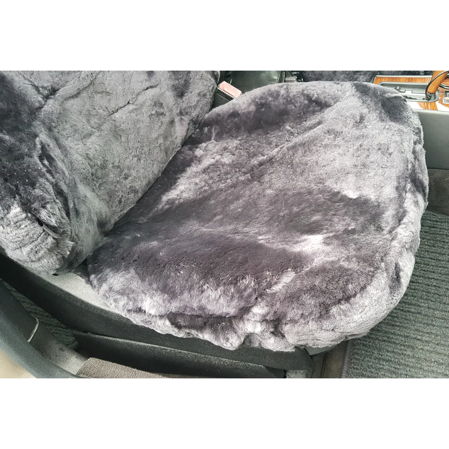 Detailansicht der mit einem Passformbezug aus Lammfell in Farbe Anthrazit bezogenen Sitzfläche im Mercedes W201 (190er)