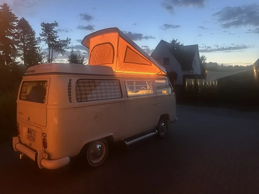 VW T2 Campingbus mit Aufstelldach in Abendstimmung, ausgestattet mit Autositzfellen aus Lammfell