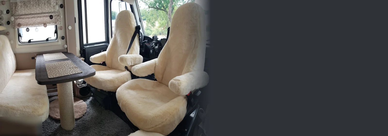 Wohnmobil-Innenraum mit Lammfellbezügen in Champagner auf Pilotensitzen, Armlehnen und Sitzbank