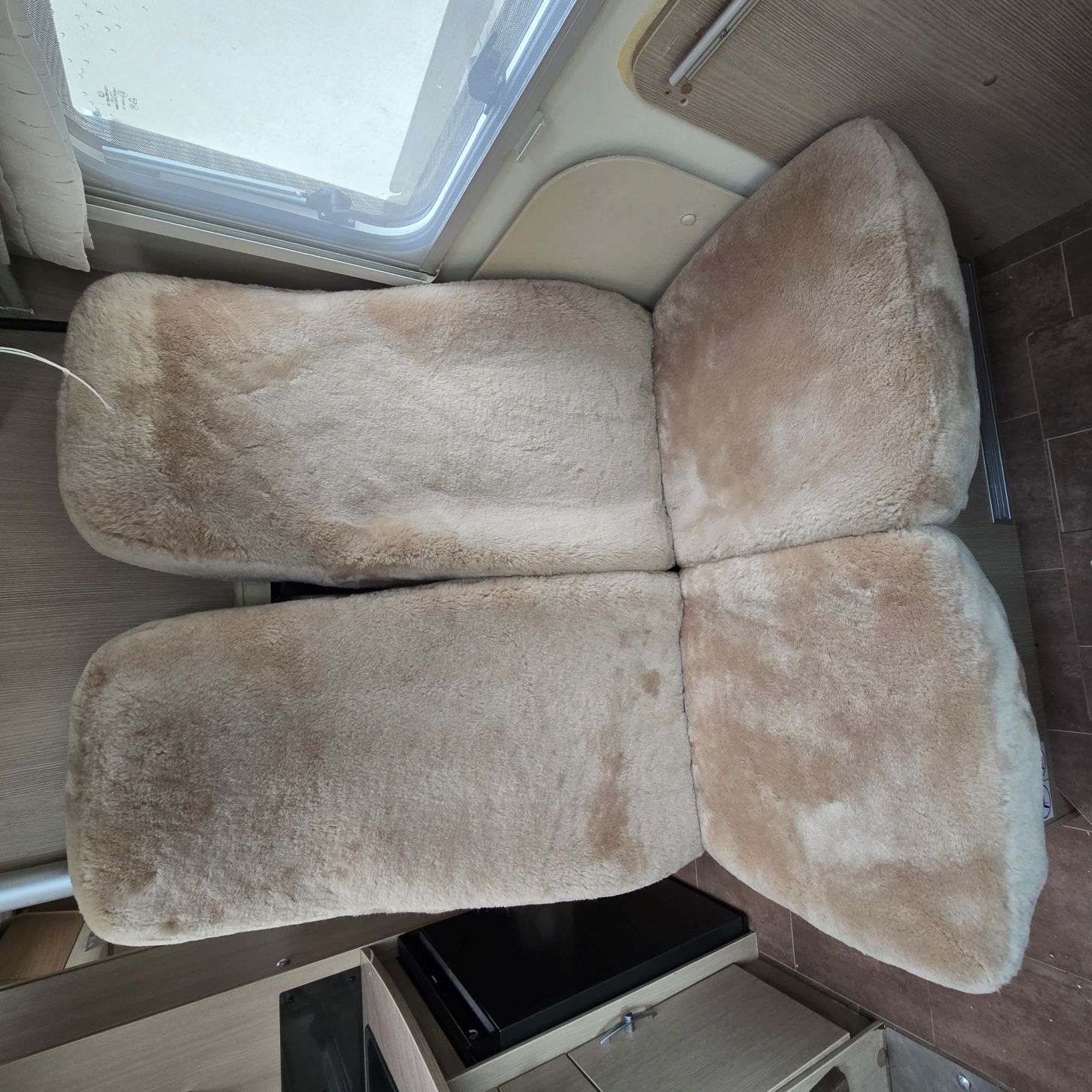 Hintere Einzelsitze eines Wohnmobils mit maßgefertigten Sitzbezügen aus Lammfell in Farbe Sand