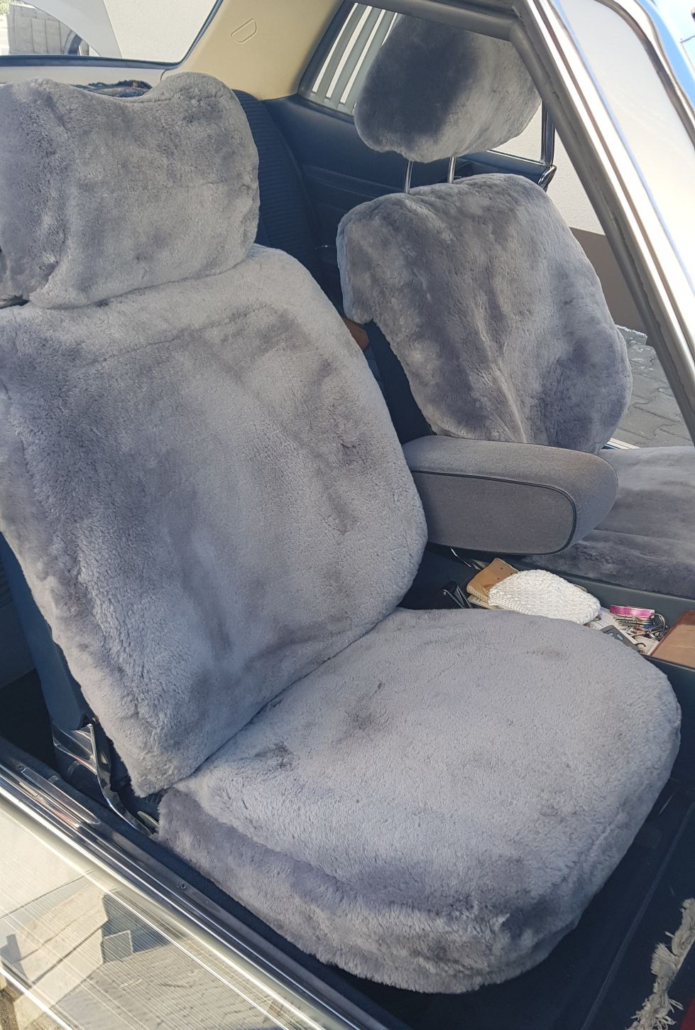 Maßgefertigter Autositzbezug aus Lammfell für Mercedes C107 SL-Klasse in Farbe Silber mit bezogener Kopfstütze.