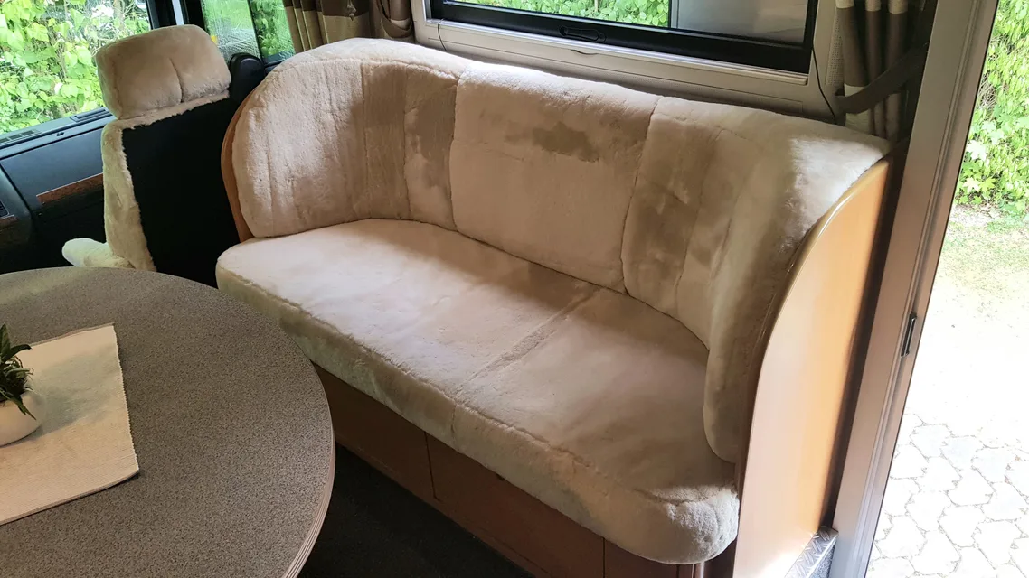 Sitzbank im Wohnmobil mit Lammfellbezügen in Sekt