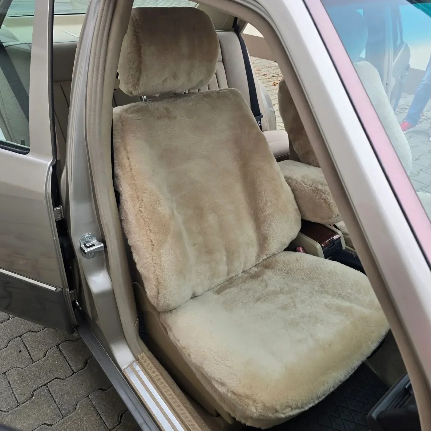 Autositzbezug aus Lammfell für Mercedes W124 in Farbe Sand mit bezogener Kopfstütze und Mittelarmlehne