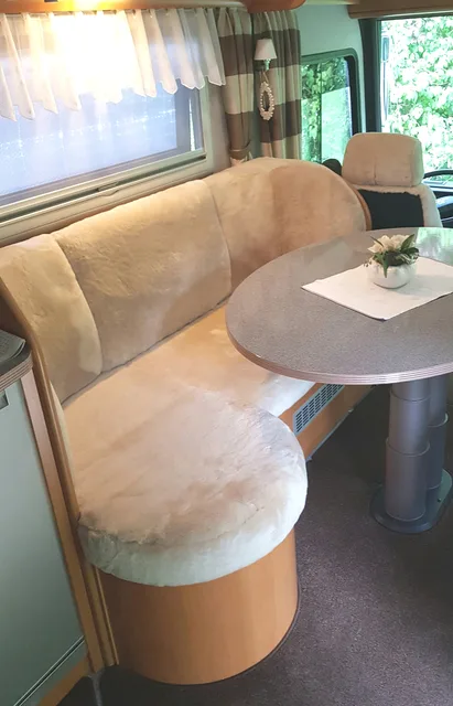 Sitzgruppe mit runder Sitzbank im Wohnmobil, Lammfellbezüge in Sekt