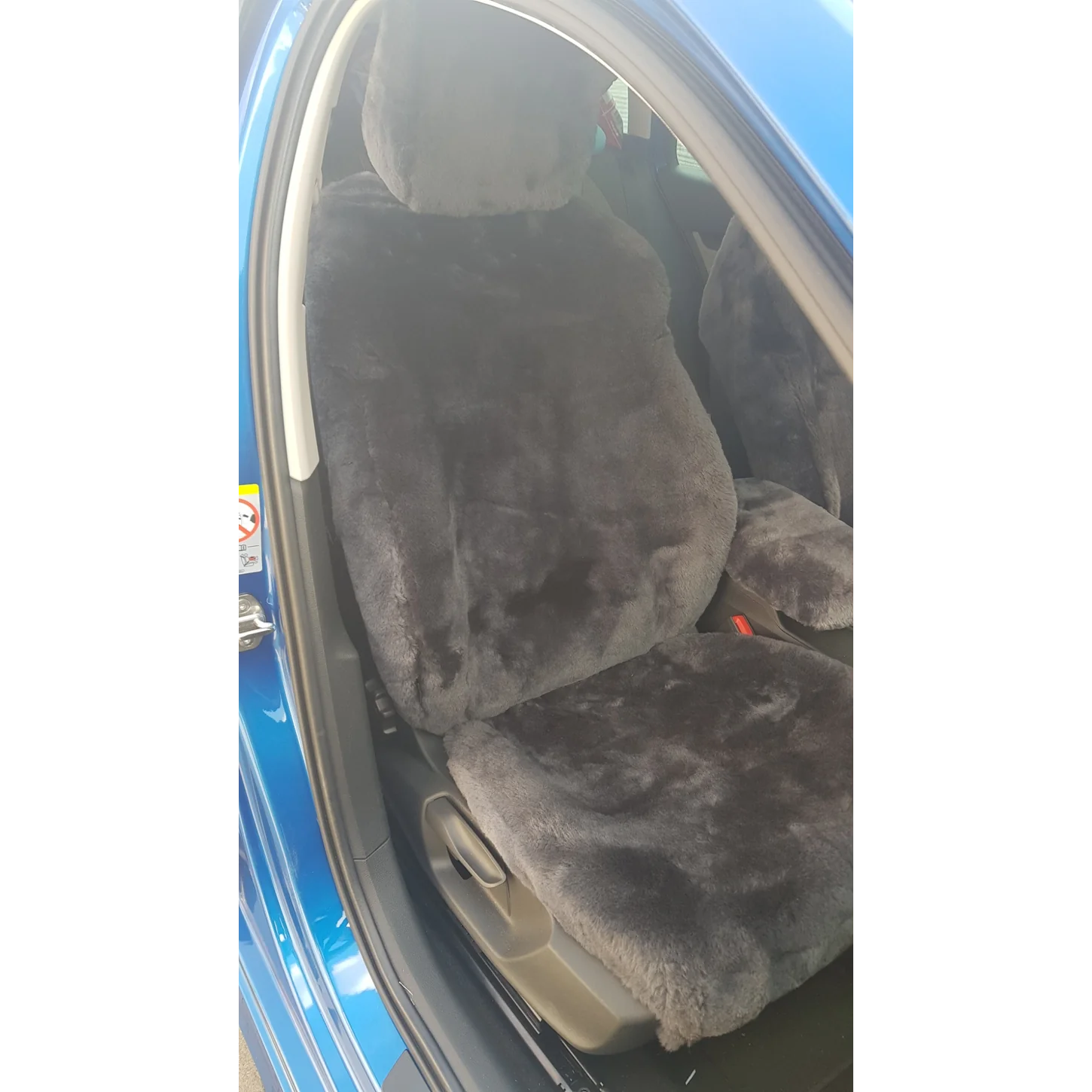 Maßgefertigter Autositzbezug aus Lammfell für Skoda Octavia IV in Farbe Anthrazit auf dem Fahrersitz mit bezogener Kopfstütze, Seitenansicht